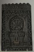 AN ISLAMIC BLACK WOOD RELIGIOUS PLAQUE, 50cm x 30cm.