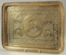 A 19TH CENTURY PERSIAN QAJAR BRASS TRAY, with engraved portraits, 37cm x 27cm.