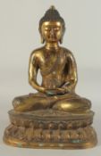 A LARGE GILT BRONZE SEATED BUDDHA, his robe with lucky symbols, 40.5cm high.