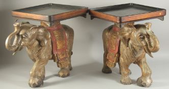 A PAIR OF GILDED AND PAINTED CARVED WOODEN ELEPHANT STANDS, 45cm high.