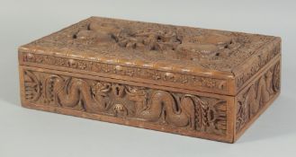 A FINE CHINESE CARVED WOOD DRAGON CIGAR BOX, the hinged lid with two relief dragons and a bird, 32cm