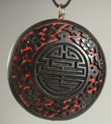 A CHINESE BLACK CINNABAR LACQUER PENDANT, 5cm diameter.