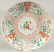 A CHINESE CORAL RED AND GREEN PORCELAIN PLATE, painted with panels of birds and flora, 26.5cm