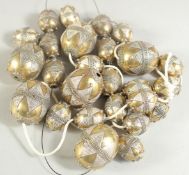 A COLLECTION OF GILDED WHITE METAL BEADS, various sizes.