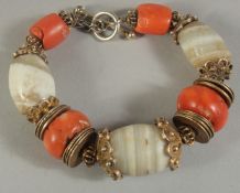 A MIDDLE EASTERN BRACELET CONTAINING ANCIENT AGATE BEADS AND LARGE CORAL BEADS.