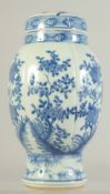 AN EARLY 20TH CENTURY BLUE AND WHITE PORCELAIN JAR AND COVER, decorated with panels of flora, 24.5cm