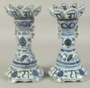 A PAIR OF CHINESE BLUE AND WHITE PORCELAIN LOTUS CANDLESTICKS, 26cm high.