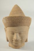 A FINELY CARVED STONE CAMBODIAN KHMER STYLE DEITY HEAD, 27cm high.