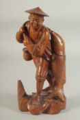 A CHINESE CARVED WOOD FIGURE OF A FISHERMAN, 26cm high.