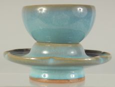 A CHINESE JUN WARE CUP ON PETAL-FORM STAND, cup 8cm diameter, 12cm diameter.