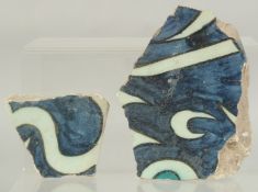 TWO 16TH CENTURY OTTOMAN DAMASCUS CALLIGRAPHIC TILE FRAGMENTS, largest 14.5cm at widest point, (2).