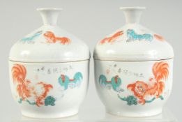 A PAIR OF CHINESE CORAL RED AND WHITE PORCELAIN LIDDED BOWLS, painted with beasts and calligraphy,