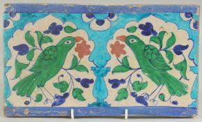 A FINE 19TH CENTURY NORTH INDIAN MULTAN GLAZED POTTERY TILE, depicting two green parrots within