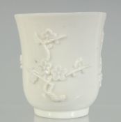 A BLANC-DE-CHINE BEAKER, with relief floral decoration, 7.5cm high, 7.5cm diameter.