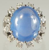 A SUPERB, OVAL CABOCHON SAPPHIRE, approx. 7cts surrounded by twelve diamonds set in 18ct gold.