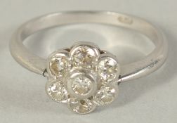 A PLATINUM AND DIAMOND FLOWER HEAD CLUSTER RING.