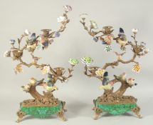 A GOOD PAIR OF PORCELAIN BIRDS on a tree, with scrolling branch and three candle holders. 24ins