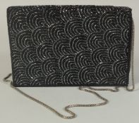 A BLACK EVENING BAG with sequins, 7.5ins long with long metal strap, 16ins long.