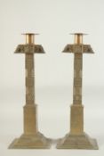 A PAIR OF, POSSIBLY AFRICAN, BRASS CANDLESTICKS. 15ins high.