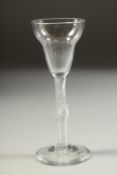 AN 18TH CENTURY ENGLISH WINE GLASS with inverted bell bowl and air twist stem, with a knop. 5.5ins