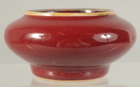 A CHINESE OX BLOOD GLAZE PORCELAIN BRUSH WASHER. 9cm diameter.