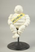 A WHITE CAST IRON MICHELIN MAN on a circular swivel base. 12ins high.
