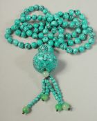 A STRING OF EIGHTY TURQUOISE BEADS AND PENDANT. 20ins long.