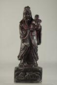 A LARGE CHINESE CARVED WOOD FIGURE holding a baby. 18ins high.,
