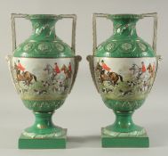 A PAIR OF SEVRES DESIGN GREEN GROUND HUNTING VASES with looped handles on square bases.