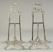 A PAIR OF SILVERED EASELS 19ins high.
