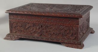 A GOOD 19TH CENTURY WOODEN BOX the top carved with a peacock. 14ins wide.