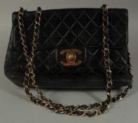 A LARGE CHANEL BLACK PADDED LEATHER BAG (USED), 11.5ins long with long entwined gilt metal and
