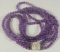 A VERY GOOD AMETHYST THREE ROW BEAD NECKLACE with gold and diamond clasp.