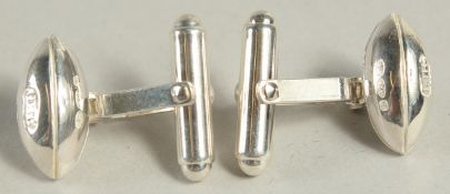 A PAIR OF STERLING SILVER RUGBY BALL SHAPED CUFF LINKS.
