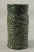 A LARGE CHINESE CARVED JADE CIRCULAR BRUSH POT, carved with dragons. 10ins high.