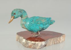 A TURQUOISE DUCK on an agate base. 3ins long.
