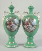 A PAIR OF GREEN GROUND SEVRES STYLES TWO HANDLED VASES AND COVERS with oval classical scenes. 1ft
