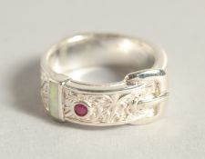A SILVER OPAL AND RUBY BUCKLE RING.