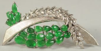 A WHITE METAL AND JADE BROOCH.