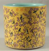 A CHINESE PORCELAIN YELLOW GROUND BRUSH POT with birds and flowers. 7ins high.