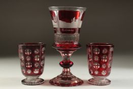 A GOOD BOHEMIAN RUBY GOBLET etched with four buildings. 8ins high and A PAIR OF BEAKERS 4ins