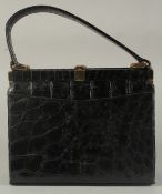 A 1950's - 1960's BLACK CROCODILE SKIN EVENING BAG, 8.5ins long with single handle.