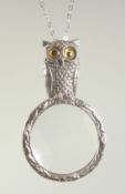 A SILVER OWL MAGNIFYING GLASS ON A CHAIN.