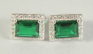 A PAIR OF SILVER AND FAUX EMERALD SQUARE SET EARRINGS