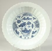 A CHINESE BLUE AND WHITE PETAL FORM LOTUS CHARGER, with ducks and aquatic flora. 41cm diameter.