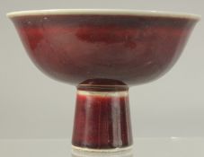 A CHINESE COPPER RED GLAZE PORCELAIN STEM CUP. 15cm diameter.