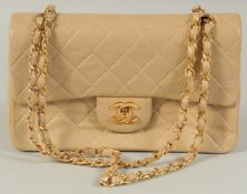 A CHANEL PADDED CREAM LEATHER HANDBAG with entwined leather and gilt strap, 9.5in wide.