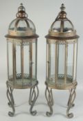 A PAIR OF METAL CIRCULAR LANTERNS on four curving feet.