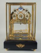A GOOD ROLLING BALL MOON CONCAVE CLOCK with six dials, brass mounts, glass cover, on a stand with