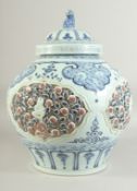 A LARGE CHINESE BLUE, WHITE AND UNDERGLAZE RED PORCELAIN JAR AND COVER, with relief panels depicting